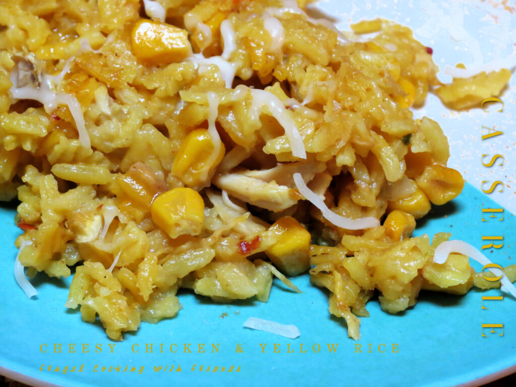 Oven Baked Casserole Dish with Yellow Rice, Cooked Chicken, Corn, Cream of Chicken, Chopped Onion and Shredded Cheddar Cheese, pictured on a plate. 